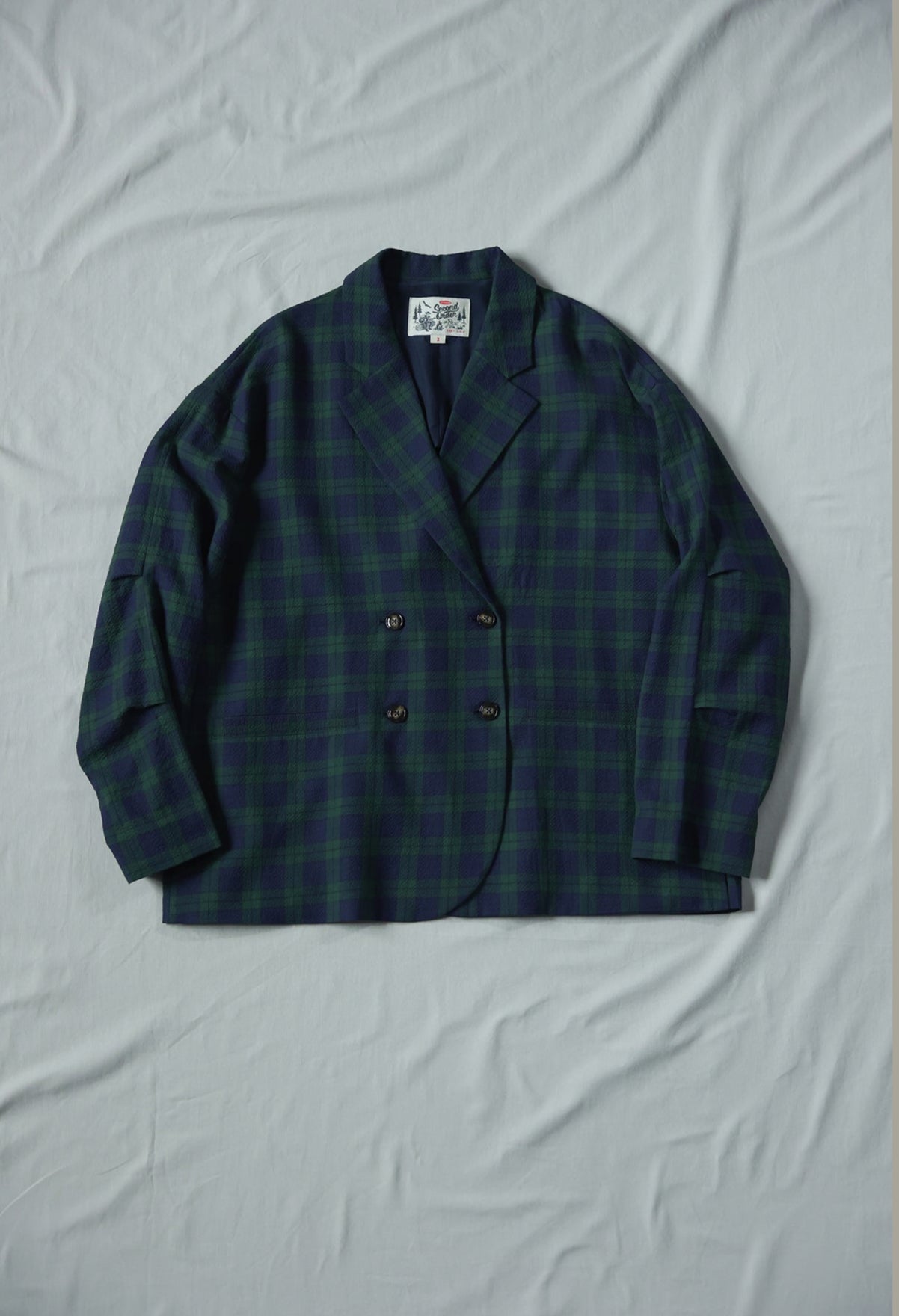 Green checkered blazer on a light gray background