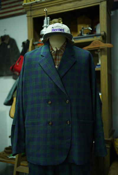 Blue plaid jacket on a mannequin with a helmet in a workshop setting
