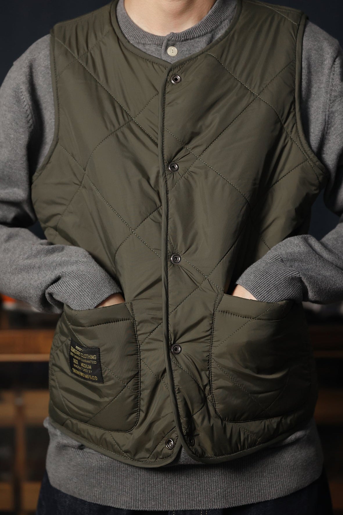 Dark green reversible vest with quilted design and jacquard knit detail.