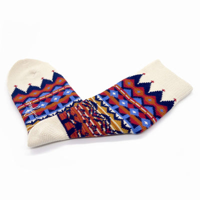 Thick white cotton crew socks with tribal-inspired patterns on neutral background.