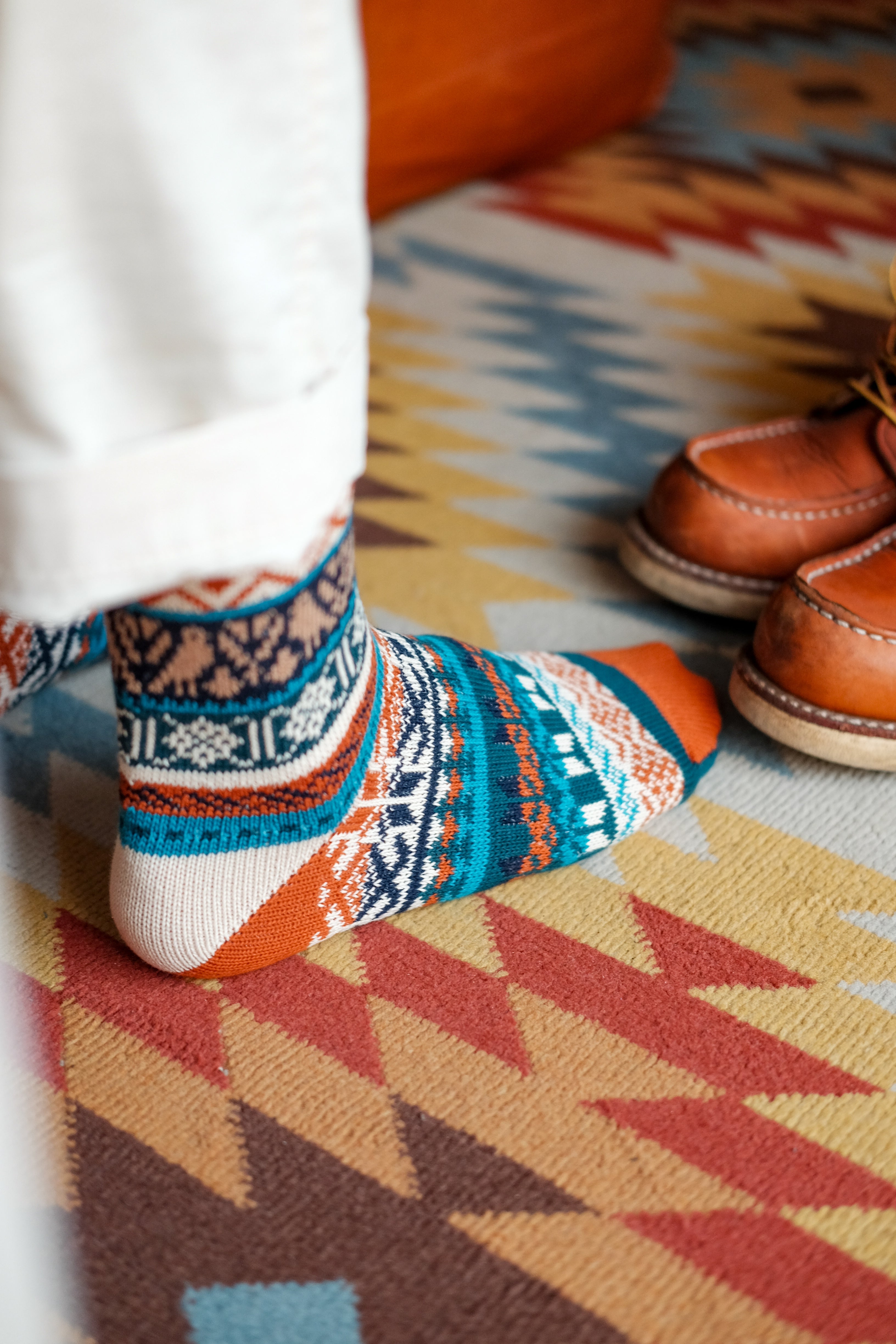 Blue and orange Boi tribal socks styled on Navajo patterned rug – ComfySocks
