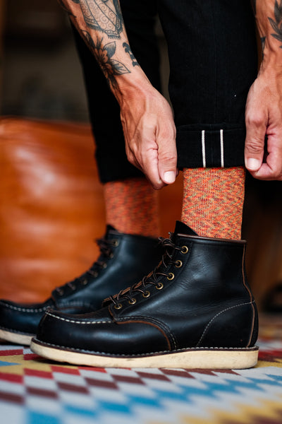 t: On-foot shot of men’s tribal pattern crew socks styled with sneakers.