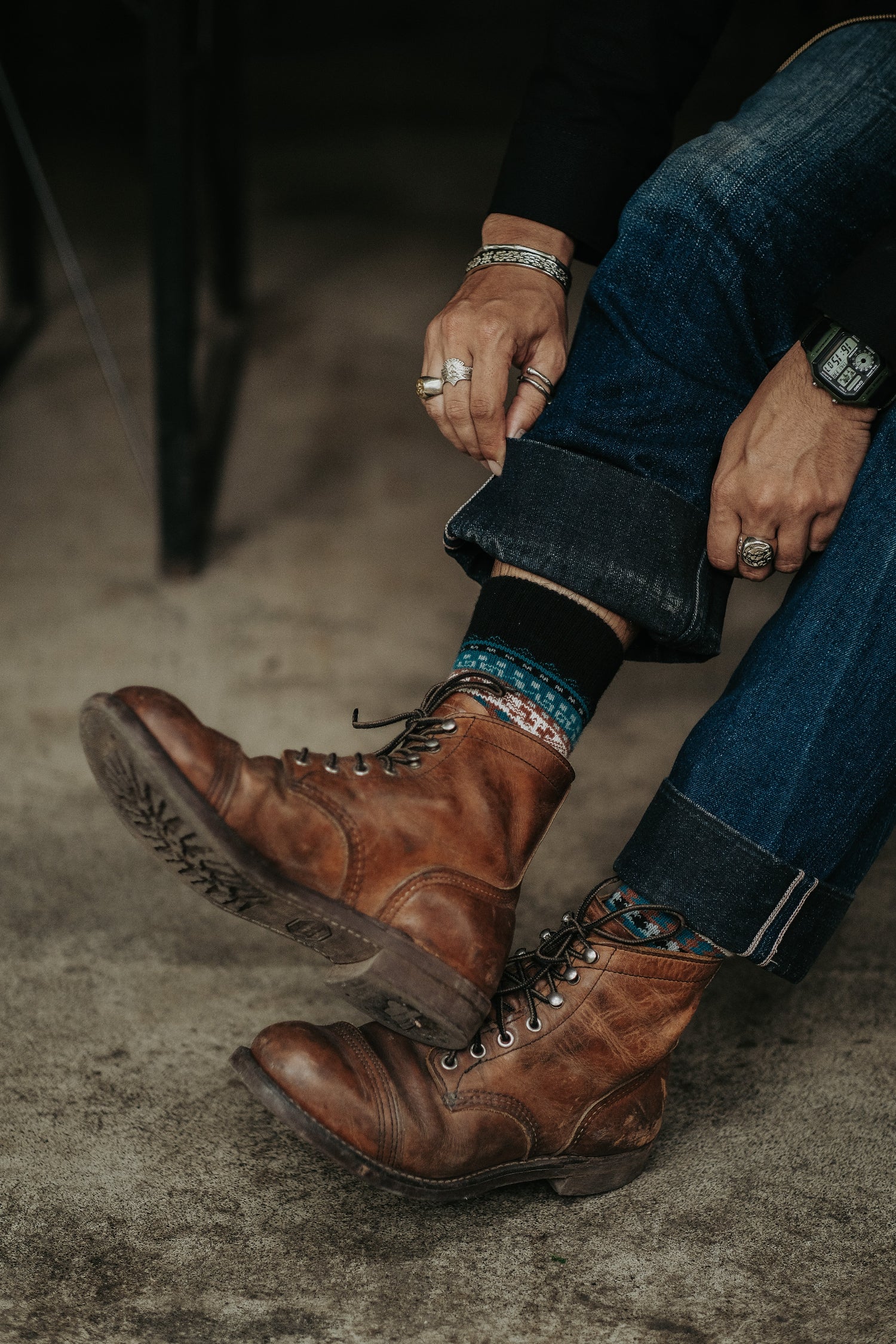 Cool thick tribal patterned socks peeking from brown boots, styled for men and women.