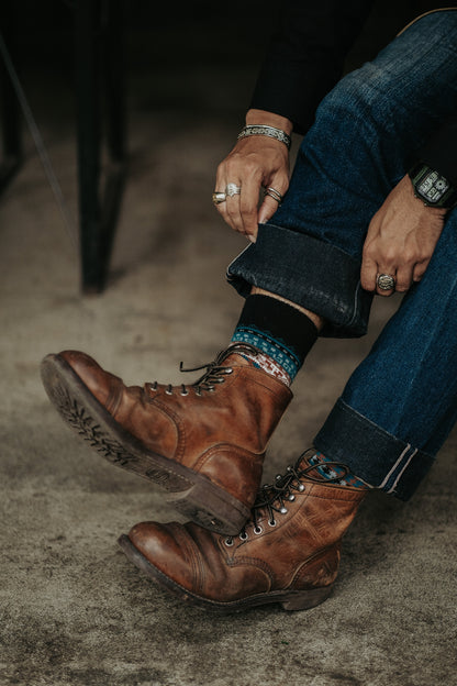 Cool thick tribal patterned socks peeking from brown boots, styled for men and women.