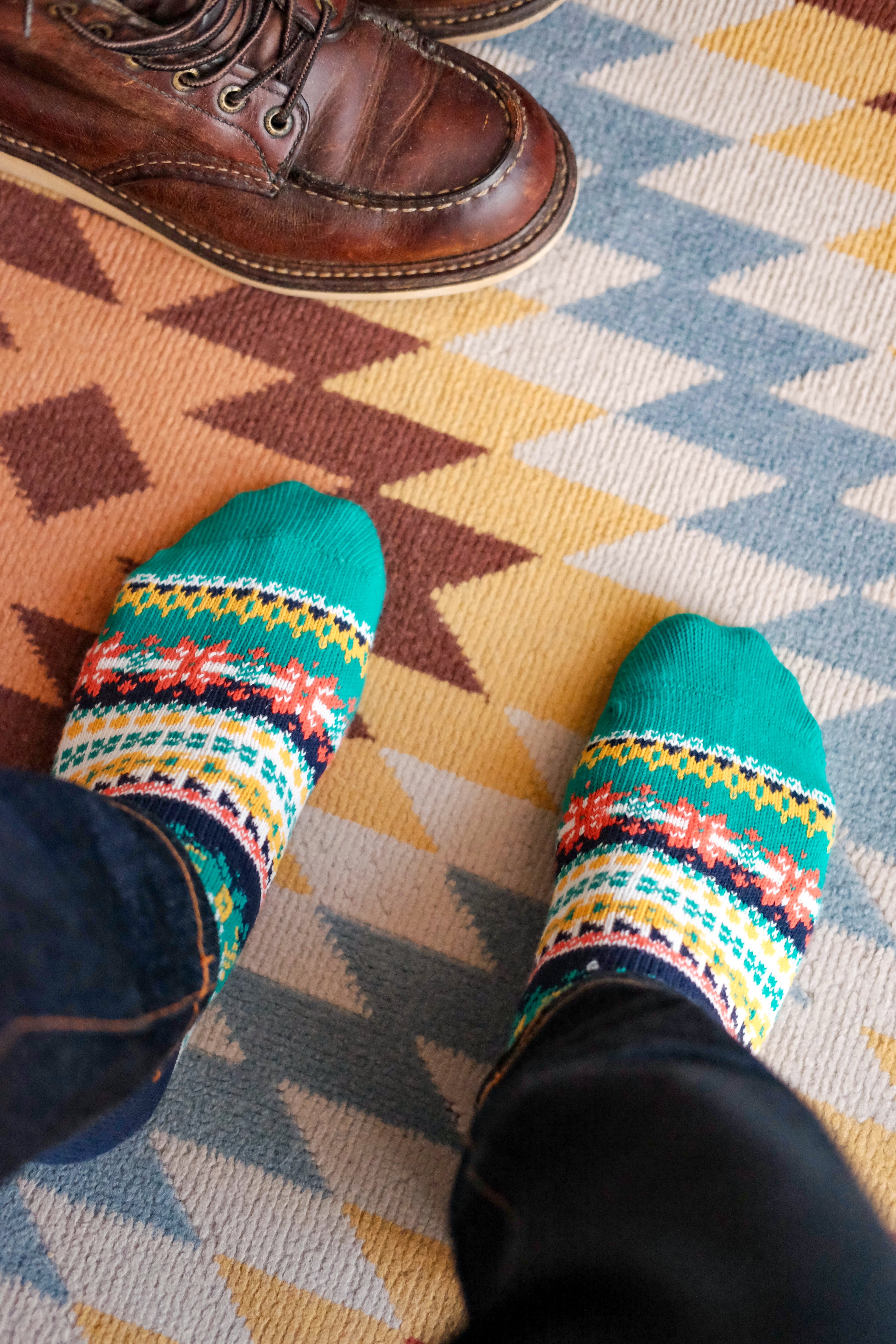 Green Nordic patterned crew socks worn with brown leather boots on rug – ComfySocks