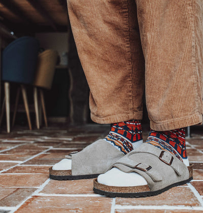 Tanami Tribal White socks with bold tribal patterns styled with brown Birkenstock sandals.